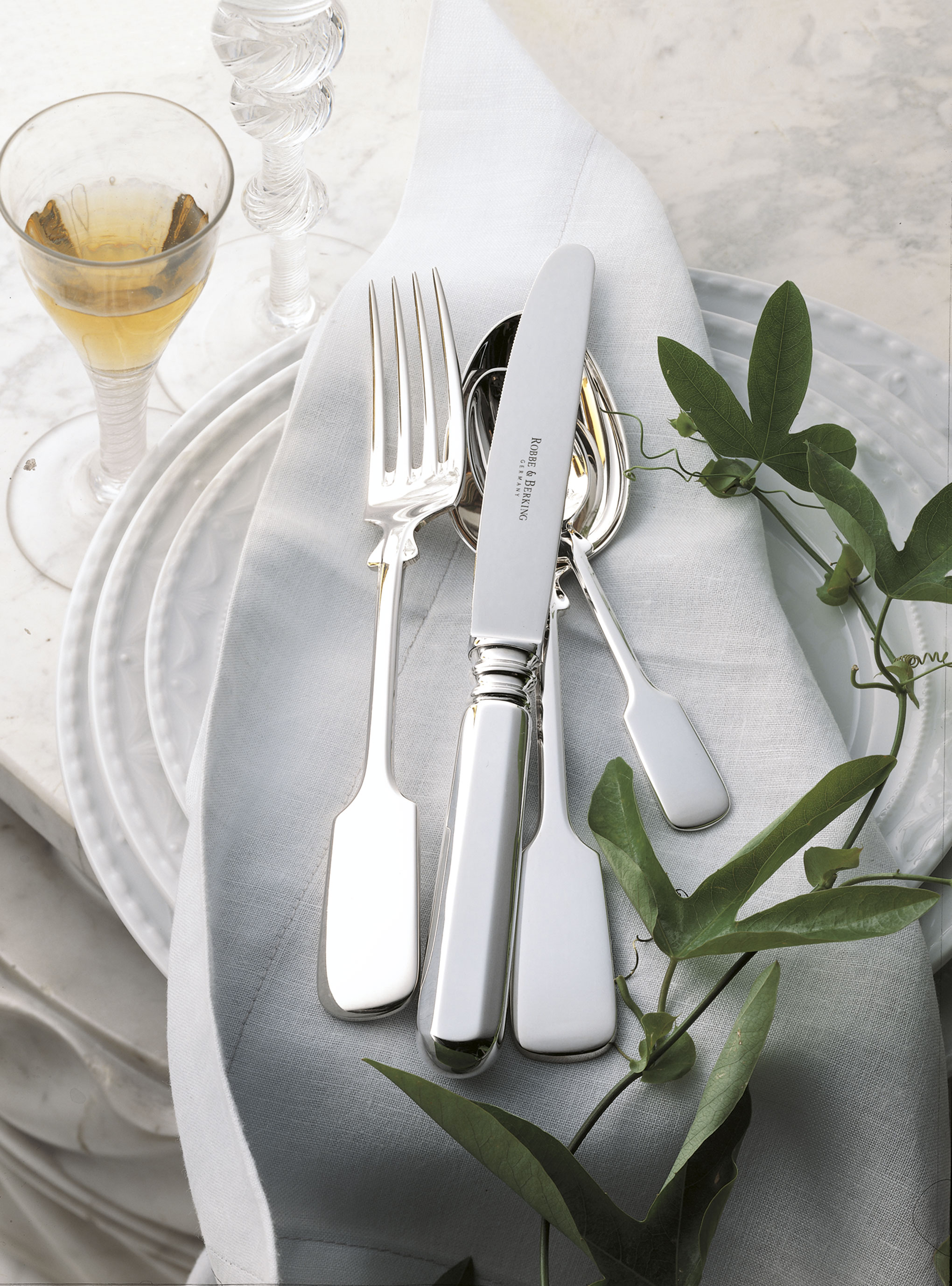 hochwertiges Silberbesteck dekorativ auf einem Teller liegend