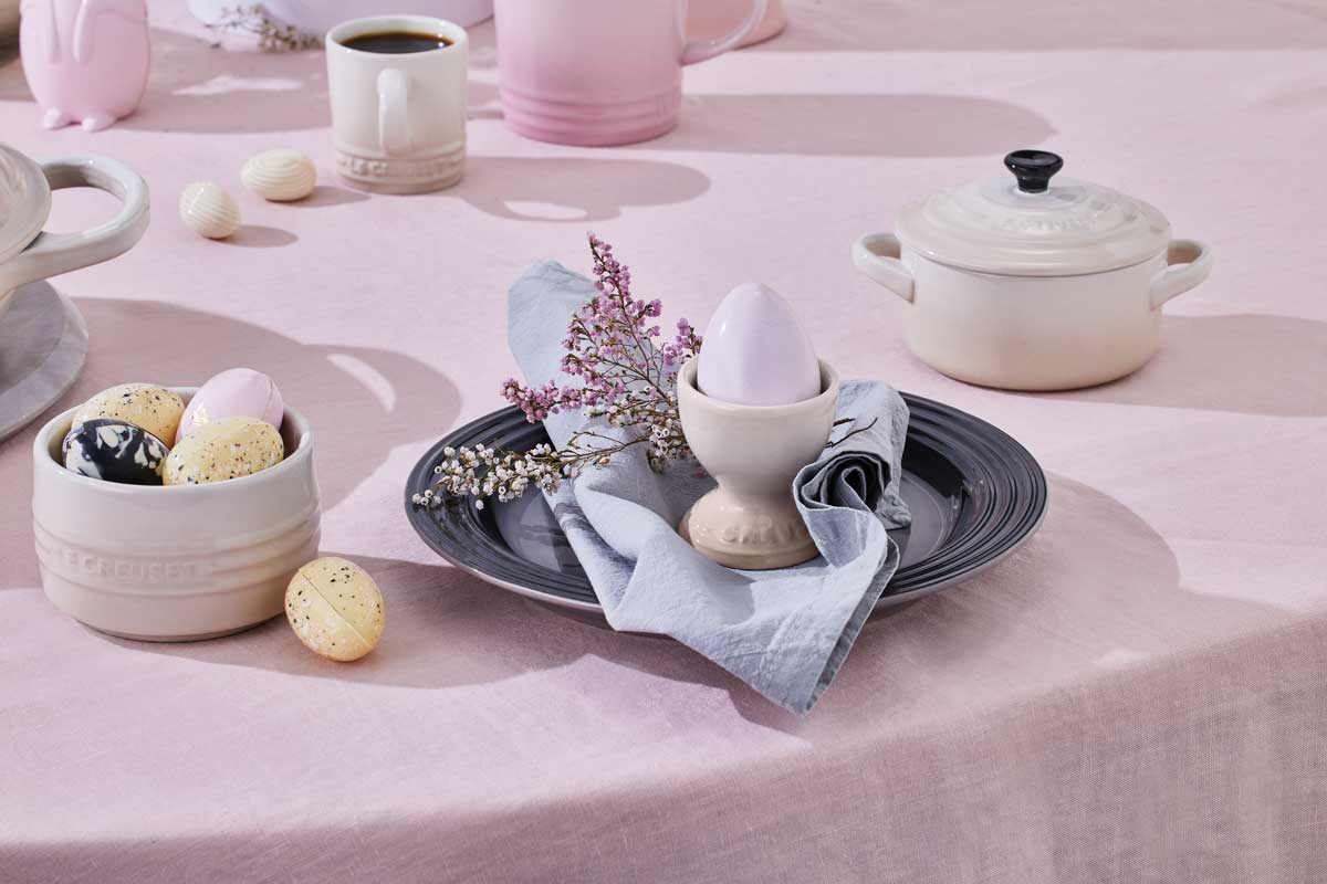 gedeckter Ostertisch mit Tassen, Teller, kleinen Töpfen, Eierbecher mit Geschirr von LeCreuset in Pastelltönen