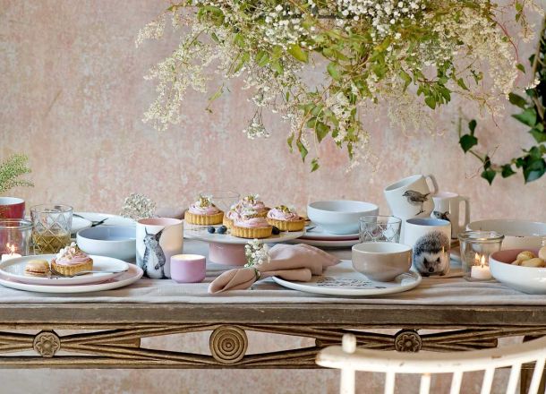 Tafelgedeck mit pastallfarbenen Tellern, Schüsseln, Tassen mit Tiermotiven