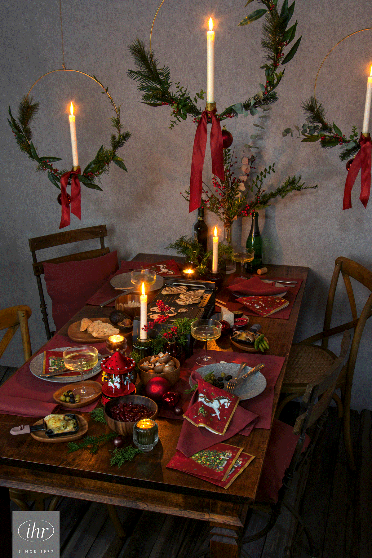 weihnachtlich gedeckter Tisch mit festlichen Servietten (Motive Schaukelpferd, Weihnachtsbaum) 